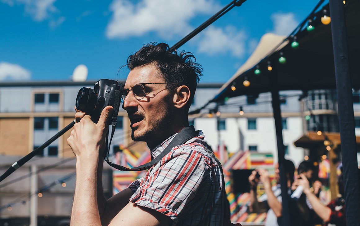 a man lifts a camera to his face
